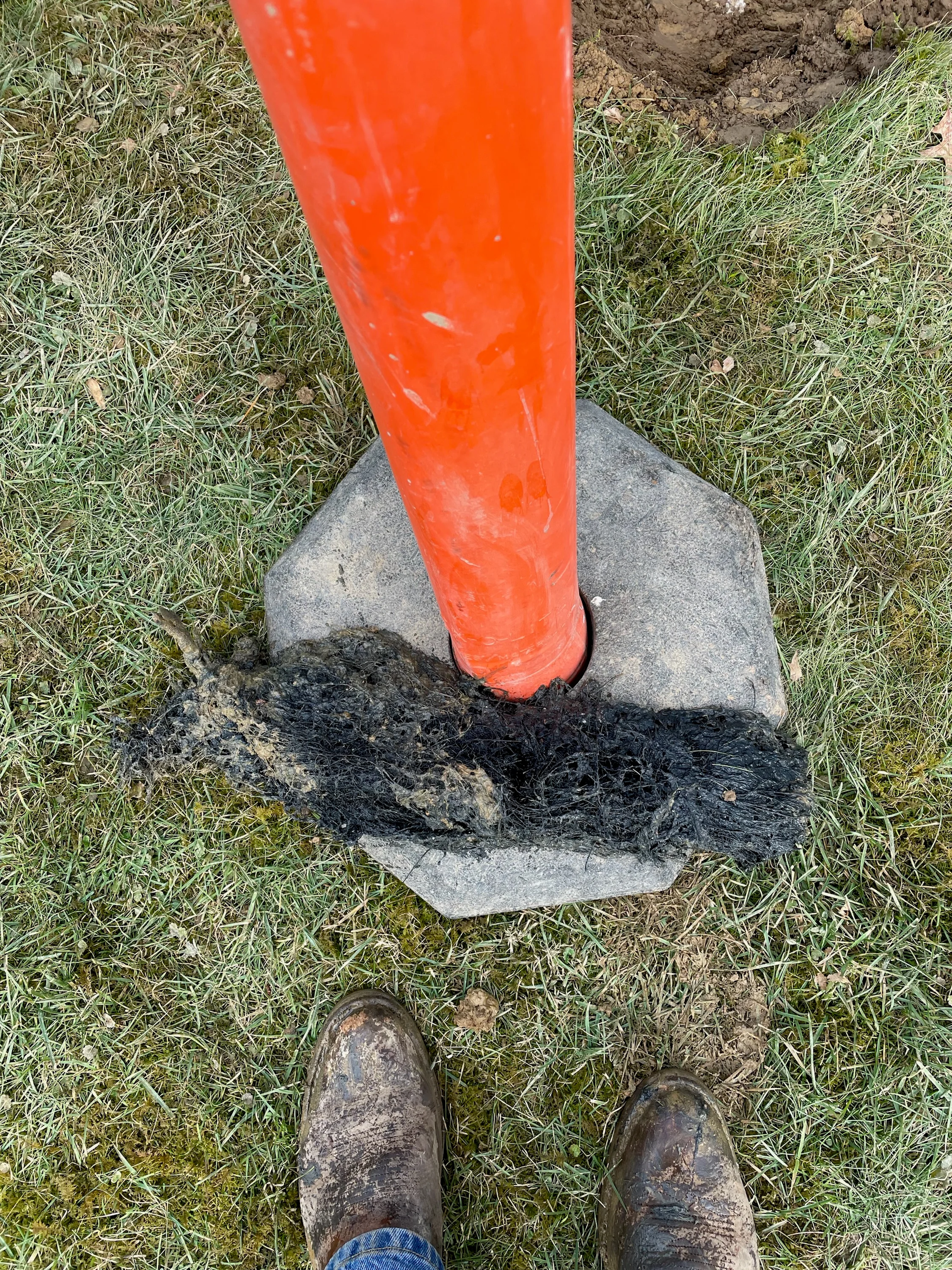 Orange PVC pipe installed on concrete base for trenchless plumbing repair